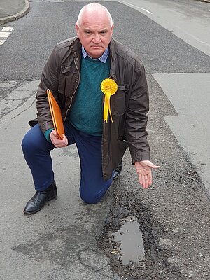 John James pointing out a bad pothole in Castle Square in Melbourne