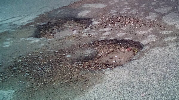 Pair of potholes straddling the carriageway